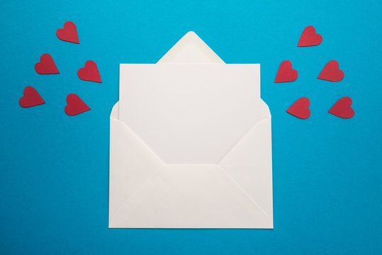 White envelope with hearts on blue background  