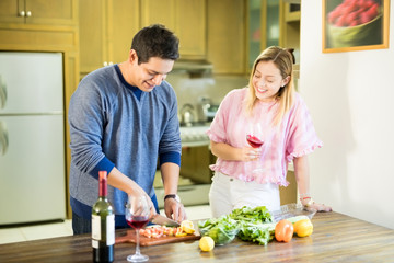 Man cooking in kitchen with girlfriend