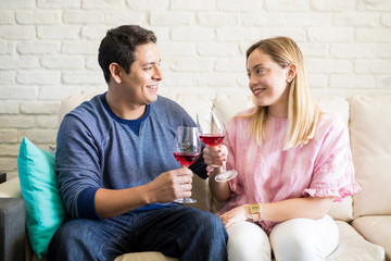 Young couple celebrating with wine at home