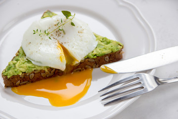 Sandwich with avocado and poached egg. Healthy breakfast