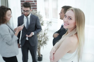 successful young woman - a company employee against the backdrop of colleagues