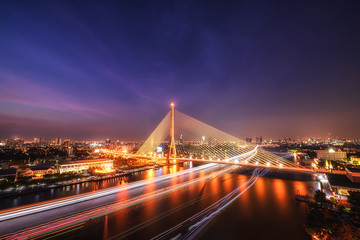 Fototapeta na wymiar King Rama 8 bridge famous transportation facility in bangkok during night time and light from boat under bridge
