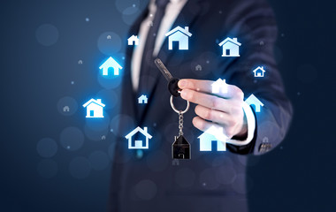 Businessman holding keys with houses around