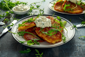 Potato pancakes, draniki, hash browns or fritters served with... fresh wild rocket leaves salad.