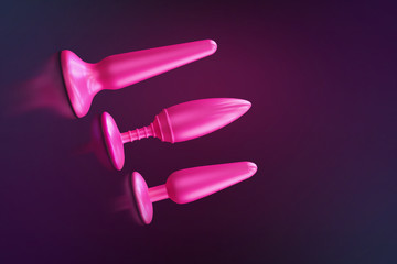 Different bdsm toys - dildo, prostate massager, vibrator, anal plug and others on a pink...