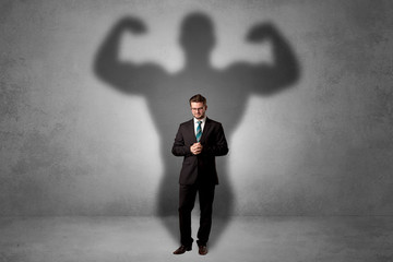 Businessman with muscular shade behind his back