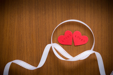 Red fondant icing for cake decoration in heart shapes with white ribbon or bow to show love...