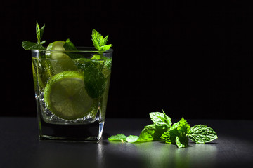 Cocktail with lime , ice  and peppermint .