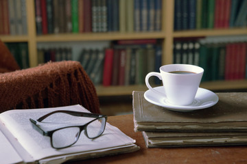 Sweet moments of relaxation with books and a cup of coffee. Vintage books, glasses, chair, library