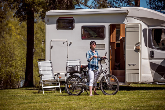 Woman on electric bike resting at the campsite VR Caravan car Vacation.
