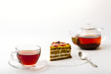 Teapot, tea cup and cake on white background