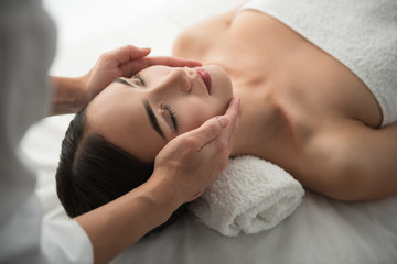 Close up of masseuse hands massaging female face. Woman closed eyes with pleasure © Yakobchuk Olena