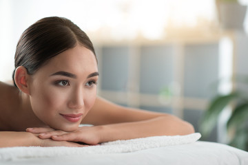 Close up portrait of beautiful female face. Calm young woman is enjoying relaxation at spa. Copy space