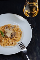 Close up of tasty spaghetti served with glass of white wine