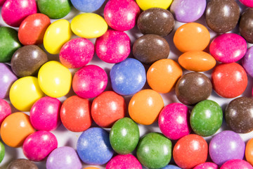 Fototapeta na wymiar Background of the colorful button shaped candies filled with chocolate