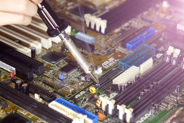 Soldering to a circuit Board of a computer close up.