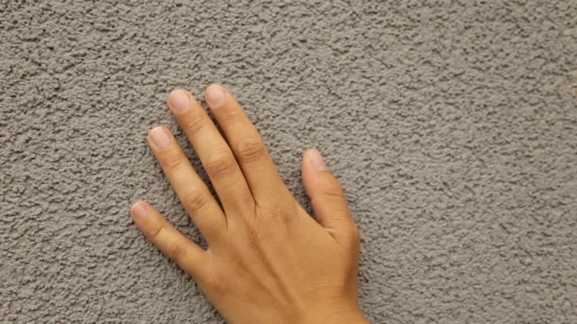 Female hand gently strokes the texture wall