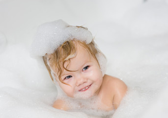 baby girl with soap suds on hair taking bath