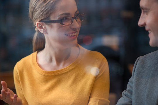 Happy female telling with glad man. She looking at him. Conversation concept