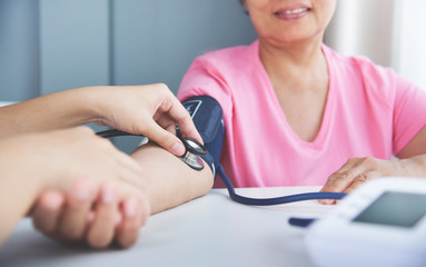 Female doctor measuring blood pressure.