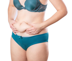 Girl with a little overweight. Young girl isolated on white background showing fat on stomach