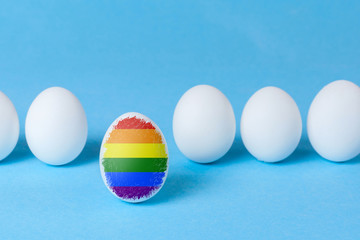 Conflict of society with LGBT people. One egg is colored in the flag of LGBT