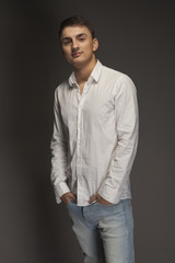 Fototapeta premium Portrait of a young man in jeans and a white shirt