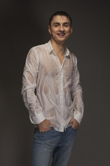 Portrait of a young man in wet jeans and a white shirt