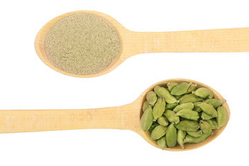 Green cardamom seeds and powder in a wooden spoon isolated on white background. Top view. lay flat