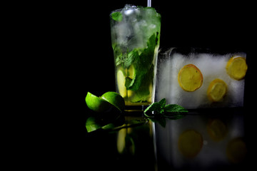 Cocktails in glass with ice cube isolated on black.