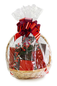 gift basket packed in transparent paper with a big red bow isolated on a white background