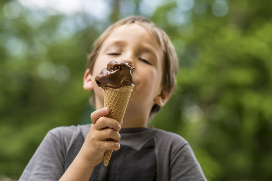 Young boy eating ice cream outdoors