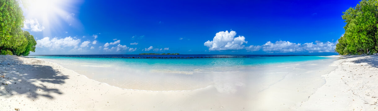 long lonely white dream beach with some clouds and sun