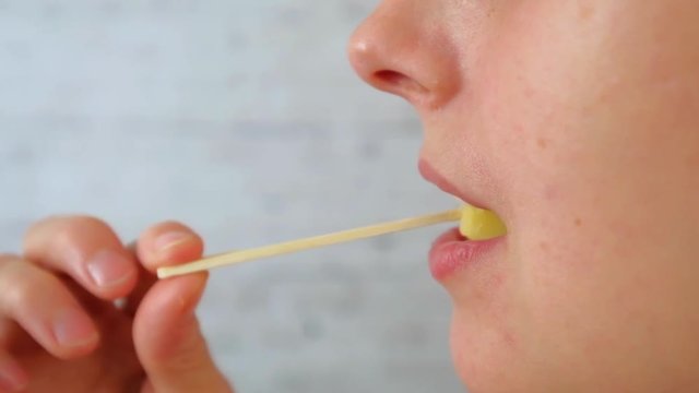 Close-up of woman face. Woman eating parmesan cheese