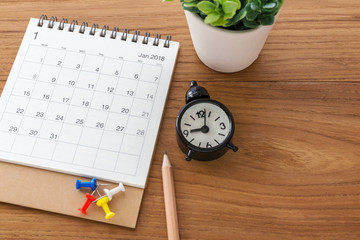 Calendar with clock on wooden background