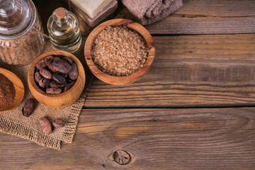 Obraz na płótnie Canvas Natural cosmetic oil, sea salt and natural handmade soap with cocoa beans on rustic wooden background