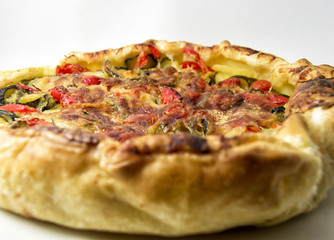 vegetables salad pie. quiche with zucchini, peppers, potatoes and puff pastry. for vegerarian cousine concept