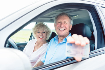 Senior Mann zeigt seinen Führerschein im Auto