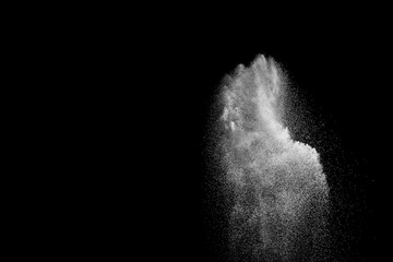 Freeze motion of white particles on black background. White granule explosion. Abstract white dust...