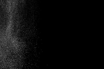 Fototapeta na wymiar Freeze motion of white particles on black background. White granule explosion. Abstract white dust overlay texture.