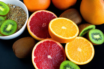 Background with citrus fruit slices with oatmeal bowl on black table