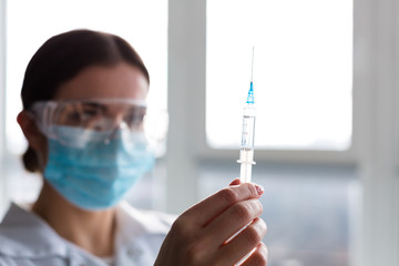 Woman laboratorian holding antibiotics samples and syringe
