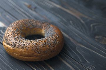Fresh bagel with poppy seed on sackcloth. Russian traditional bakery product. or bakery pastry banner, ad, poster.
