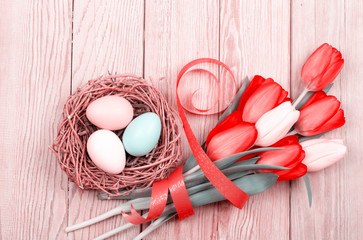Easter Eggs in a birds nest with colorful tulips