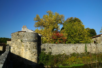 Tour et mur en pierre des fortifications de l'Abbaye de Nouaillé-Maupertuis