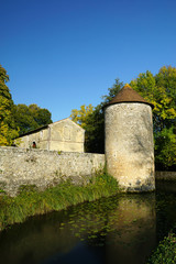 Fototapeta na wymiar Tour et mur en pierre des fortifications de l'Abbaye de Nouaillé-Maupertuis