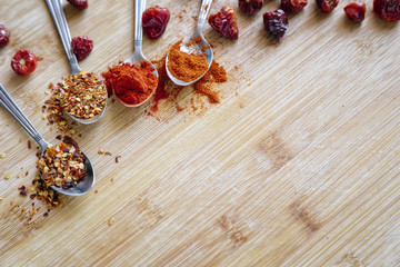 Various hot spices on a wooden background