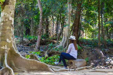 alone lady sit on wood and feel relax in forest