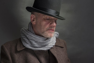 Portrait of a sinister man wearing a top hat and a grey scarf