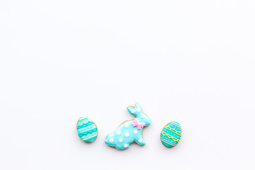 Easter background. Cookies in shape of easter bunny and easter eggs. White background top view space for text